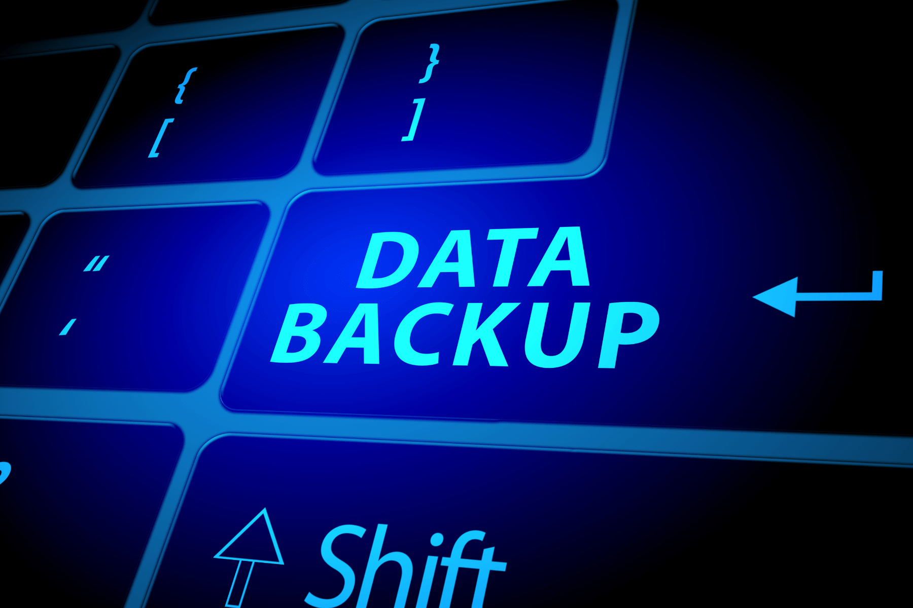 A close-up view of a computer keyboard with a blue-lit key labeled "data backup" highlighted.